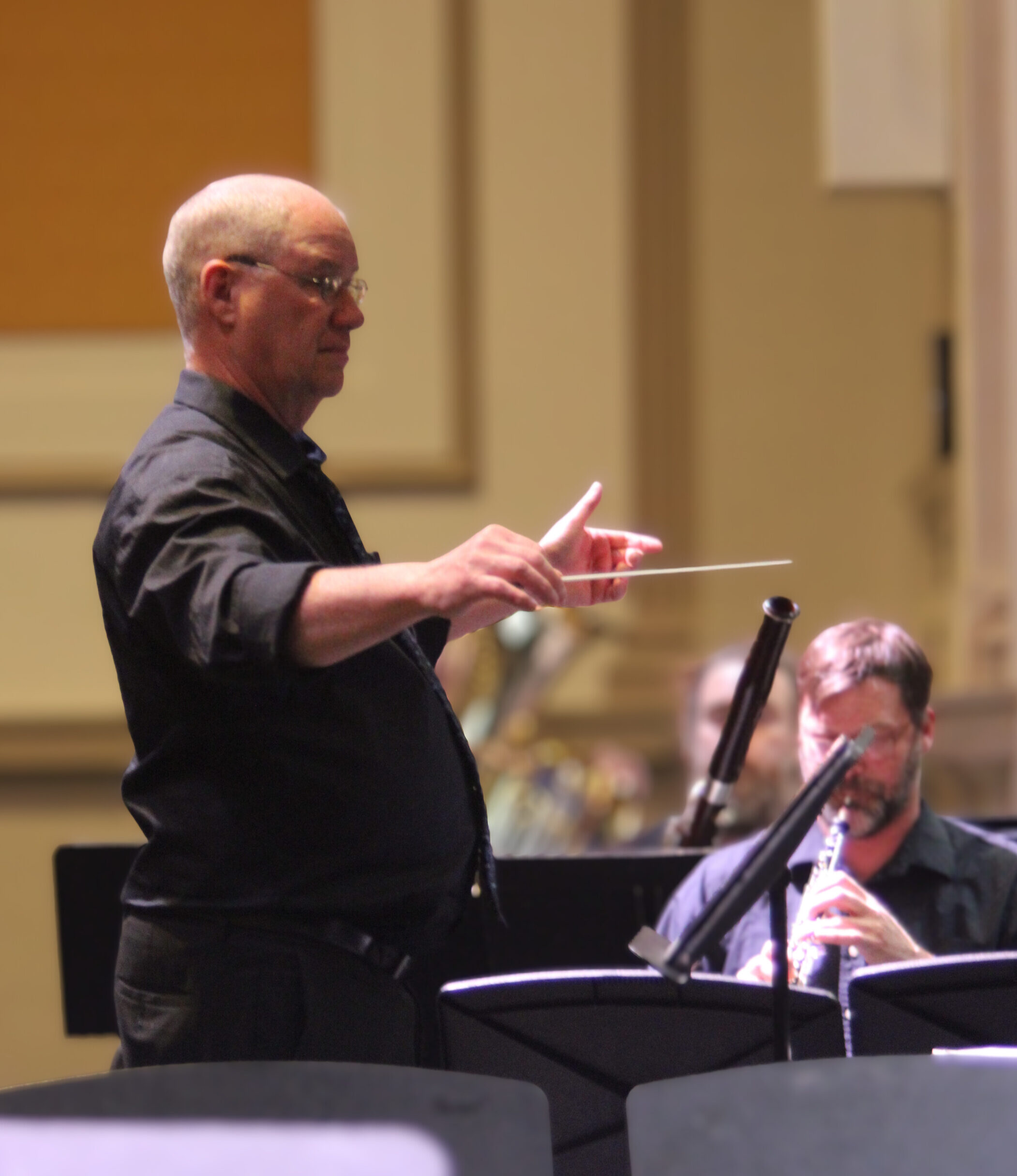 The band's music director conducting from the podium during a concert